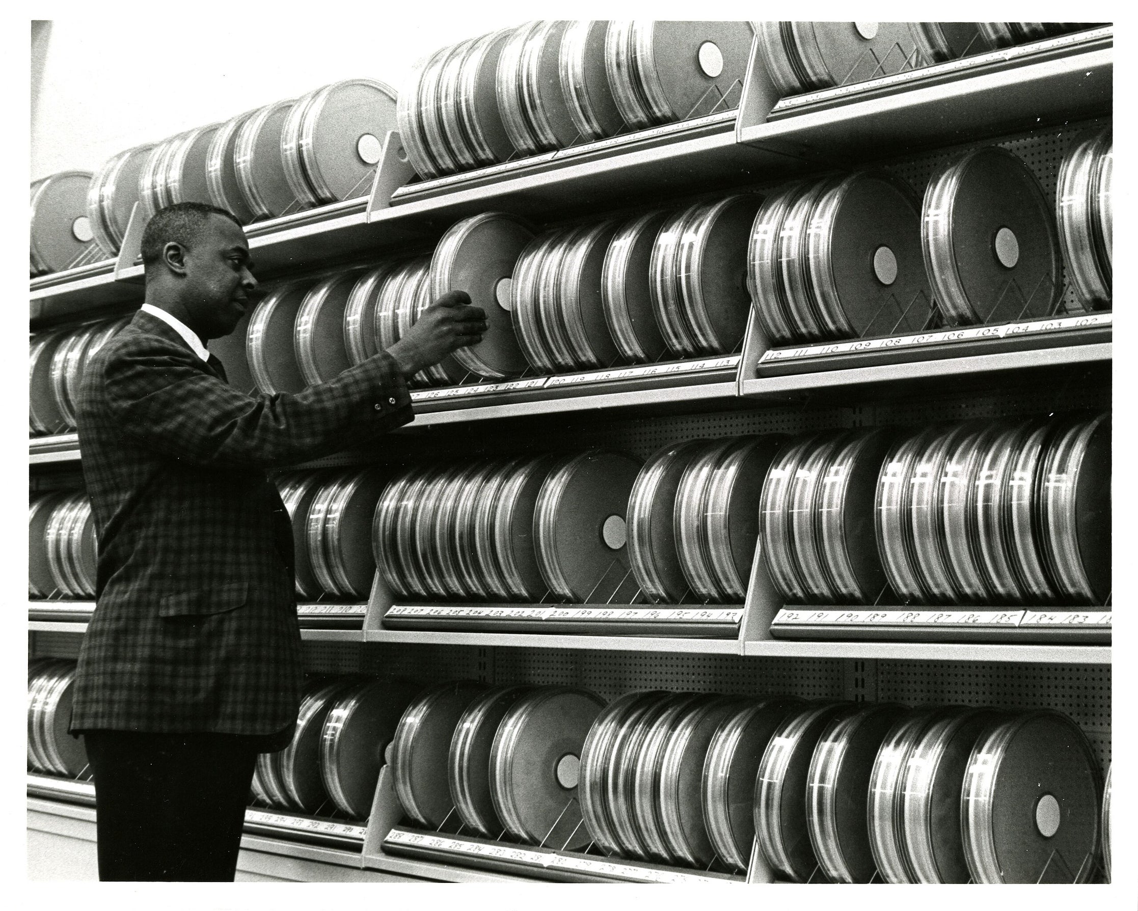 John Smith arranges cannisters of magnetic tape for computer storage
