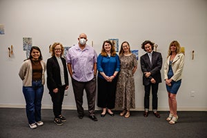 Photo of artist, panelists, and exhibition