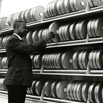John Smith arranges cannisters of magnetic tape for computer storage
