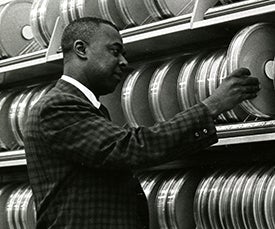 John Smith arranges cannister of magnetic tape for computer storage at the National Library of Medicine